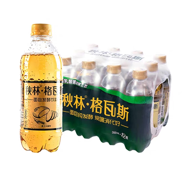 A photo of a clear bottle of gold-colored fizzy liquid, with a label depicting a loaf of bread.
