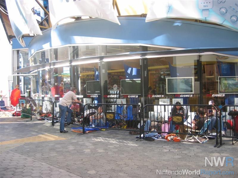 A long but calm line of people waiting outside an EB Games, busy with their various devices.